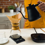 Pouring hot water from the water kettle to brew coffee
